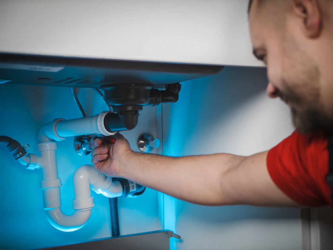 Plumber working on pipework